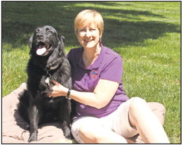 Cindy Baker of Touched by a Paw uses a calming Healing Touch for Animals technique with her dog, Carlo. PHOTO PROVIDED